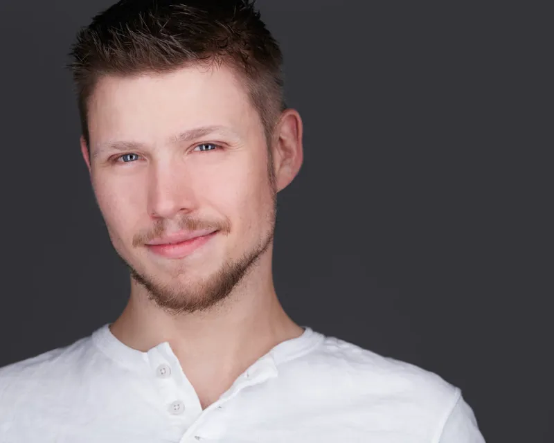 Professional actor headshot with natural lighting and simple background